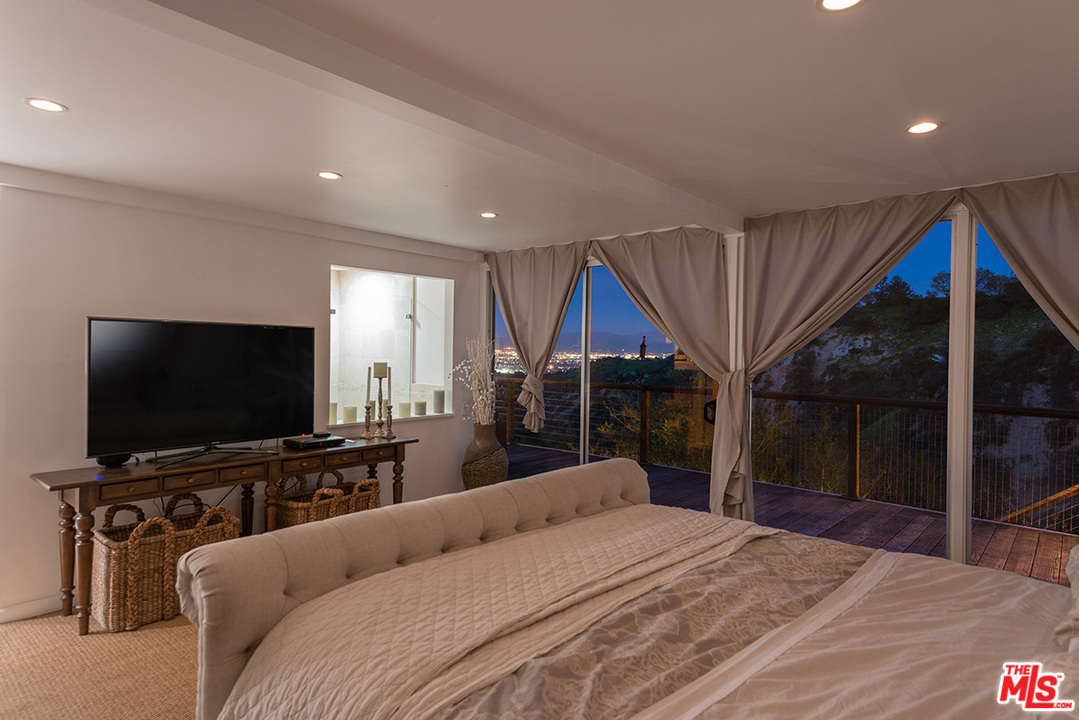 3356 Woodcliff Road Sherman Oaks, CA 91403 - Photo 6 of 15 a bedroom with a bed and a flat screen tv