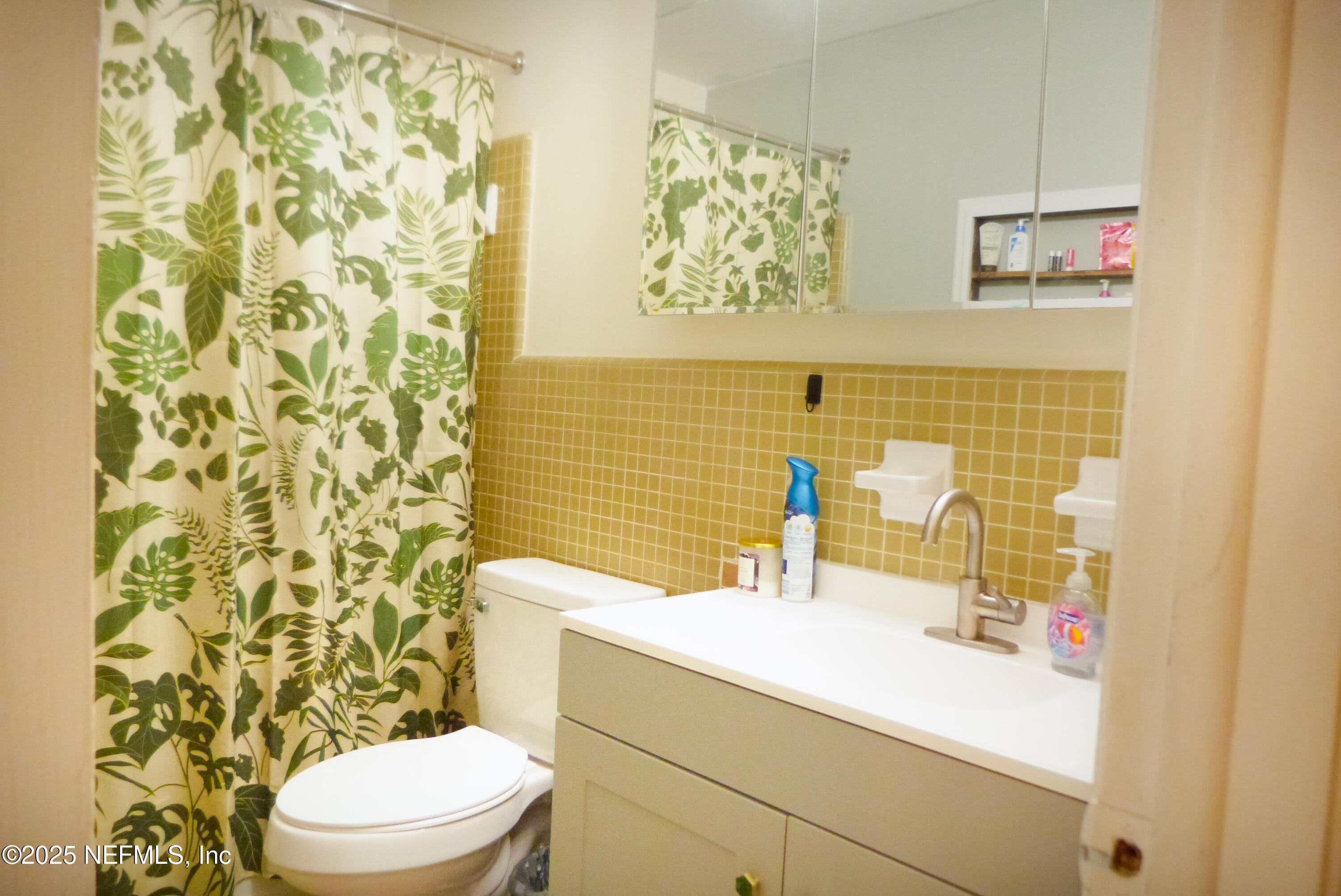7341 El Ocho Road, Unit 5 Jacksonville, FL 32216 - Photo 6 of 9 a bathroom with a sink a toilet and shower curtain