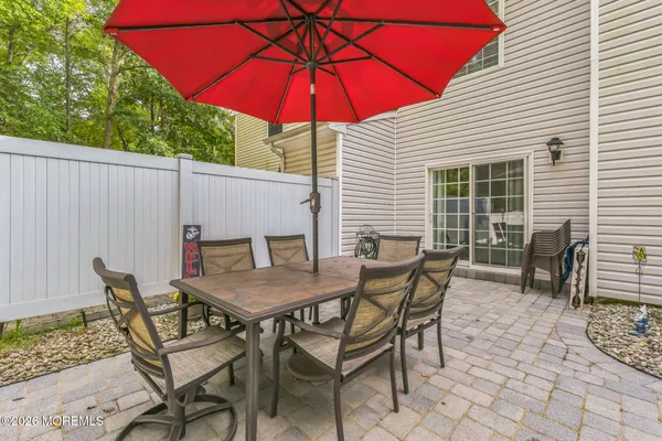 a patio with a table and chairs under an umbrella