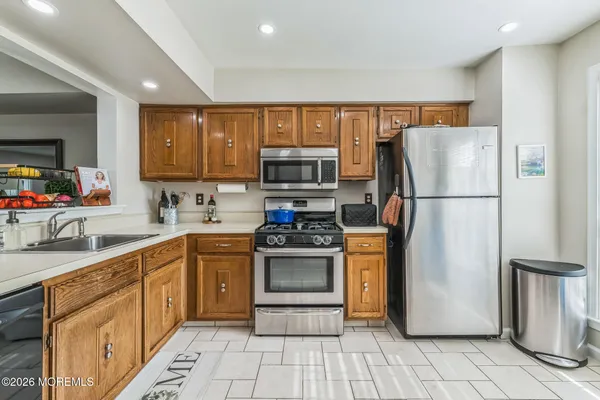a kitchen with stainless steel appliances granite countertop a refrigerator stove and sink