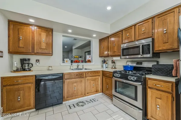 a kitchen with stainless steel appliances granite countertop wooden cabinets sink stove and granite counter top