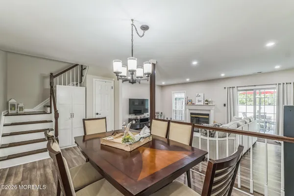 a view of a dining room with furniture a chandelier and wooden floor
