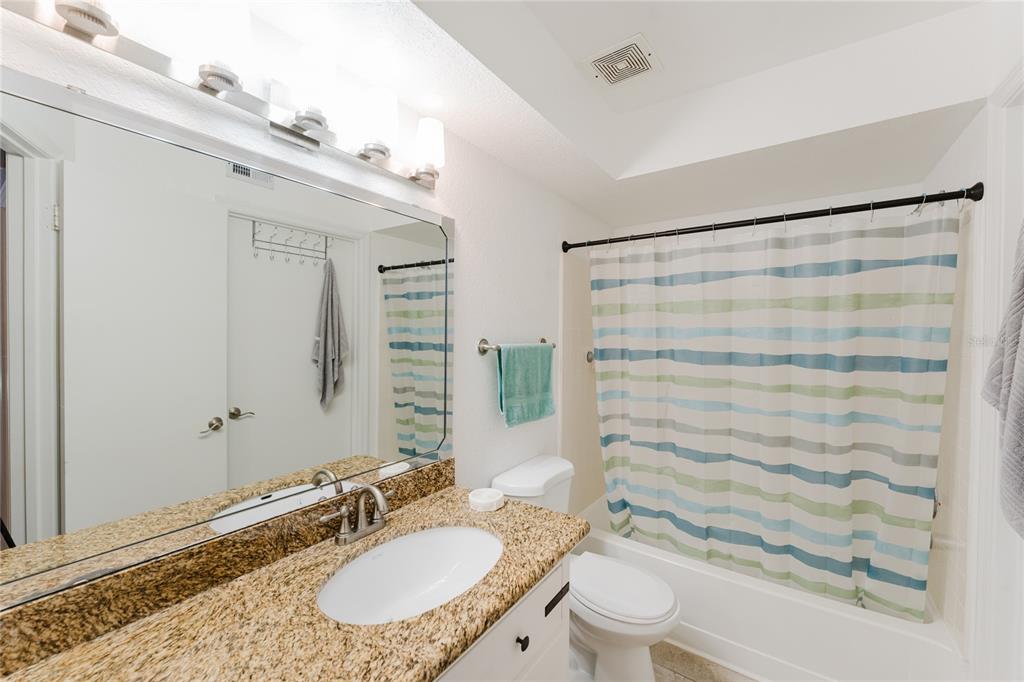 5120 Conroy Road, Unit 18 Orlando, FL 32811 - Photo 20 of 38 a bathroom with a granite countertop sink toilet a mirror and shower
