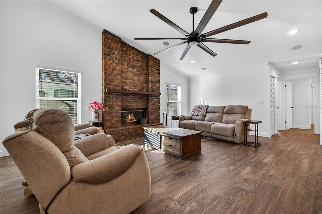 11945 74th Avenue Seminole, FL 33772 - Photo 11 of 47 a living room with furniture a ceiling fan and a fireplace