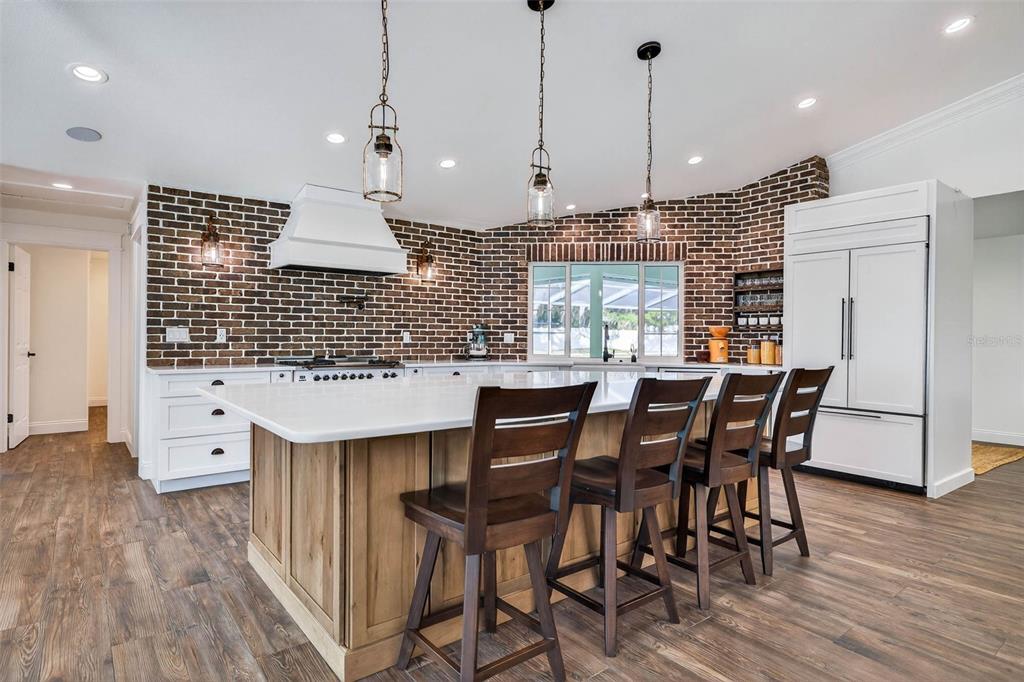 11945 74th Avenue Seminole, FL 33772 - Photo 16 of 47 a kitchen with stainless steel appliances kitchen island granite countertop a table chairs and a wooden floor