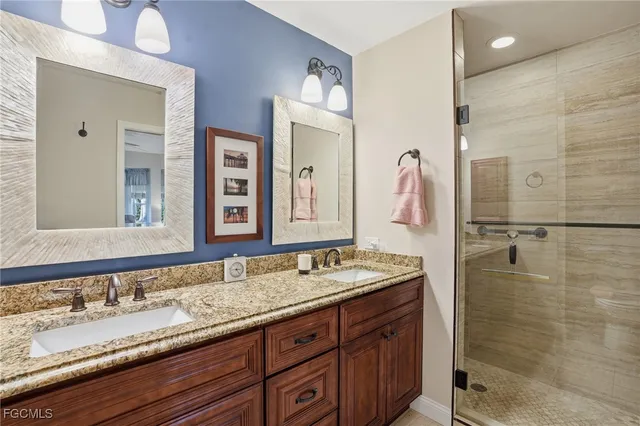 a bathroom with a granite countertop double vanity sink and a mirror