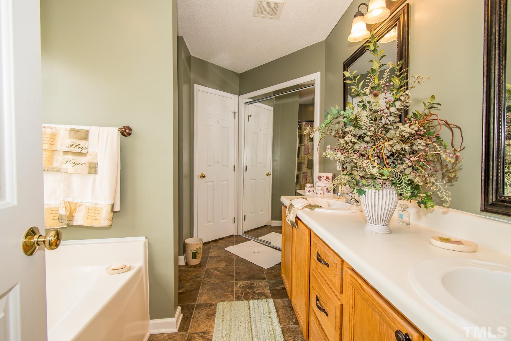 561 Yellow Berry Run Wendell, NC 27591 - Photo 22 of 27 a bathroom with a tub sink and mirror