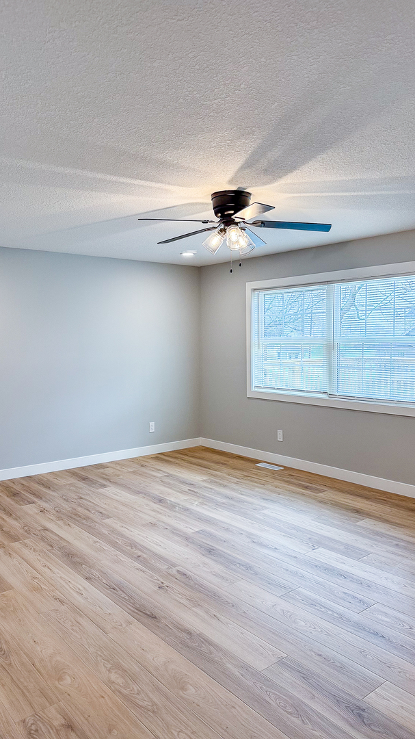 103 2nd Street Broadlands, IL 61816 - Photo 3 of 55 a view of an empty room with wooden floor and a window
