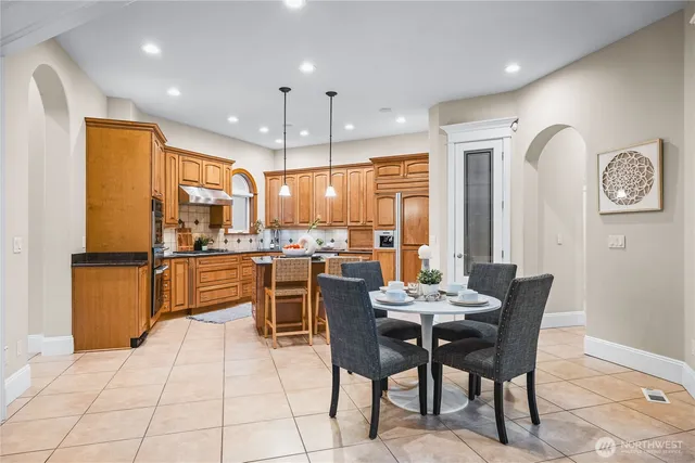 a dining area with furniture a large window and kitchen view