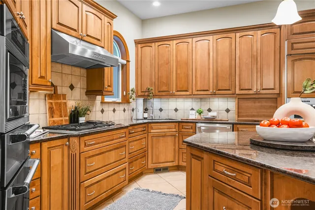 a kitchen with stainless steel appliances granite countertop a sink and cabinets