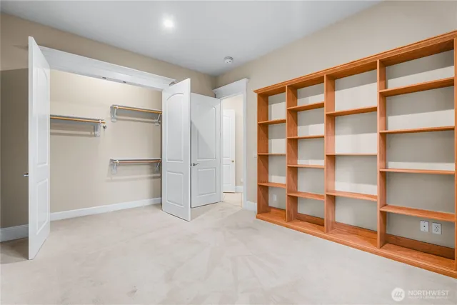 a view of an empty room with cabinet and a window