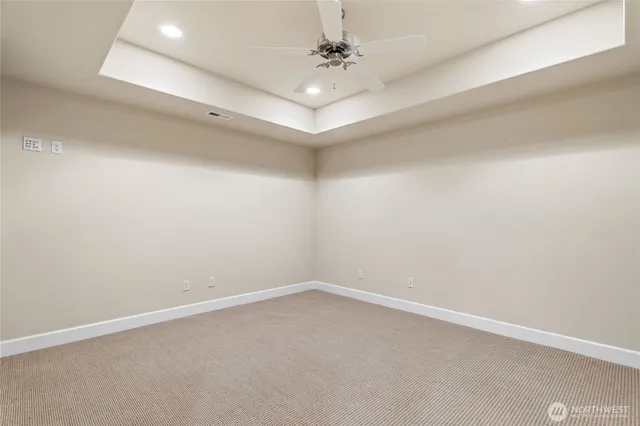 en empty room with windows and ceiling fan