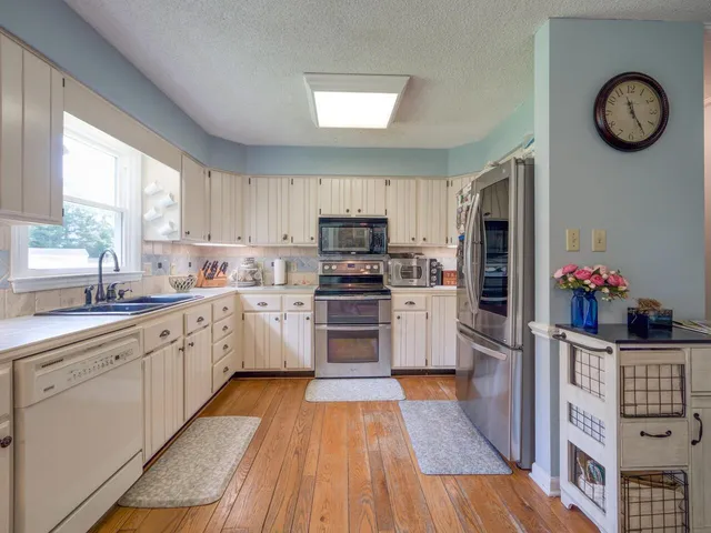 a kitchen with white cabinets sink and stainless steel appliances