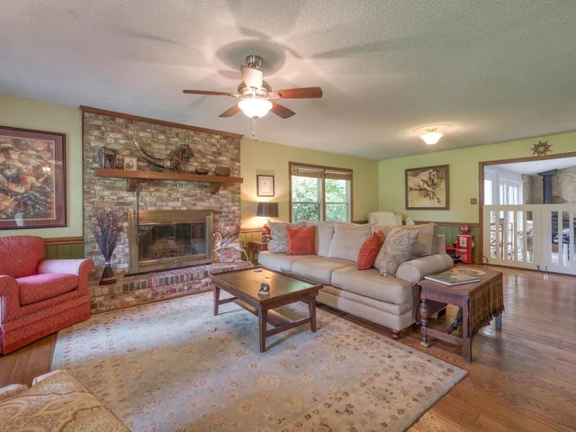 a living room with furniture a large window and a fireplace