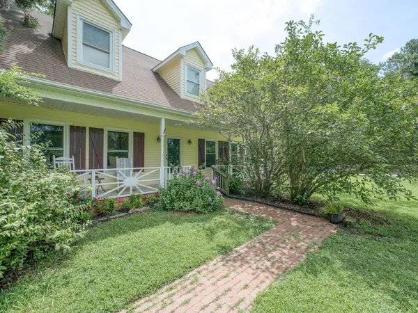 a view of a house with brick walls and a yard with plants