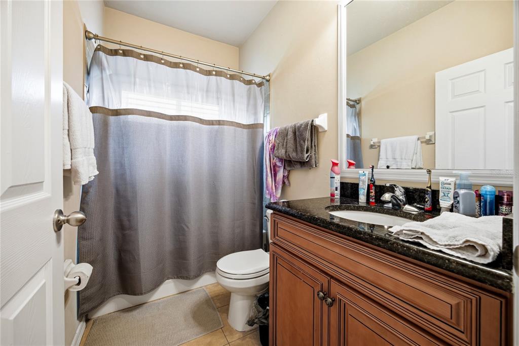 7550 Southwest 81st Way Gainesville, FL 32608 - Photo 22 of 31 a bathroom with a granite countertop sink toilet and shower