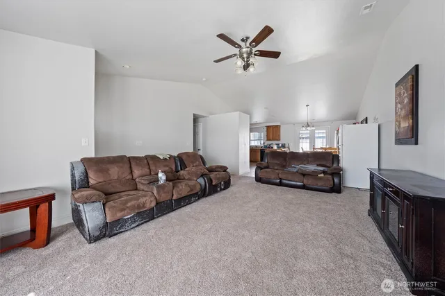 a living room with furniture and a ceiling fan