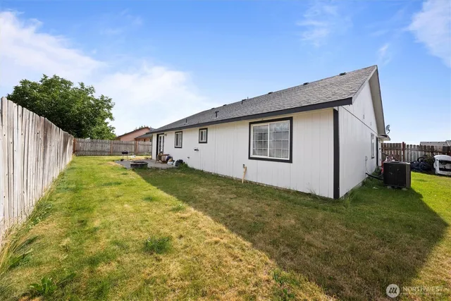 a view of a house with backyard and trees