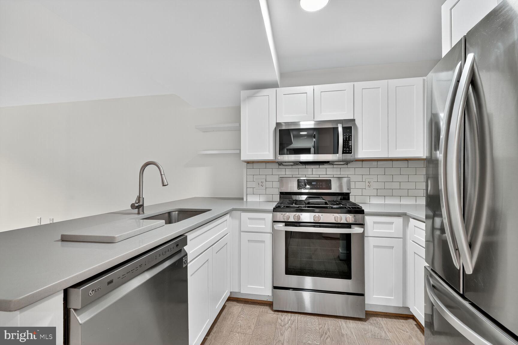 800 4th Street Southwest, Unit S221 Washington, DC 20024 - Photo 7 of 19 a kitchen with white cabinets stainless steel appliances and sink