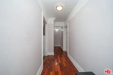 a view of a hallway with wooden floor