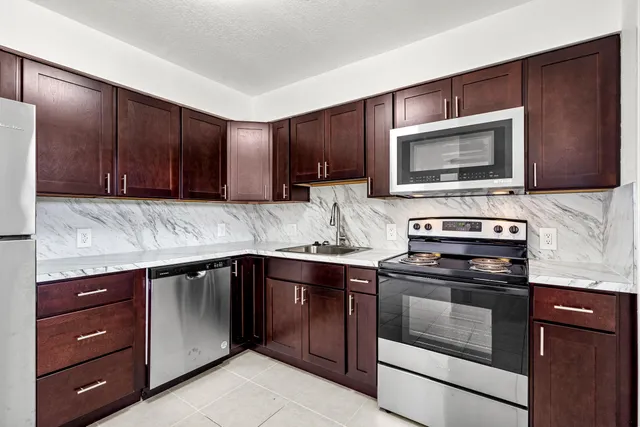 a kitchen with granite countertop wooden cabinets and stainless steel appliances