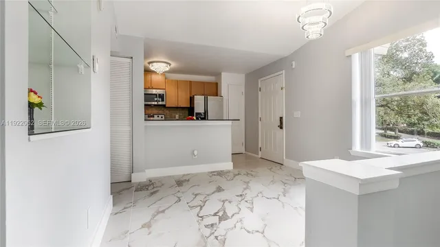 a view of a kitchen with wooden floor and a window