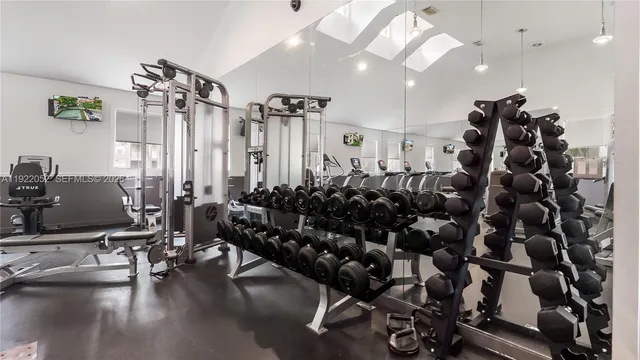 a room with gym equipment and wooden floor