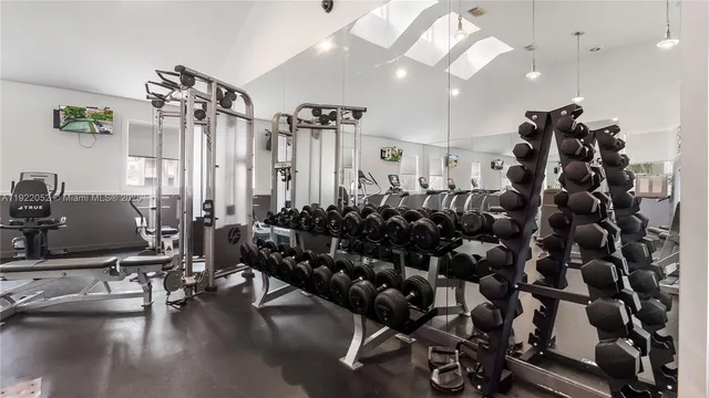 a room with gym equipment and wooden floor