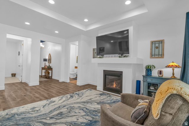 2454 West Jackson Street Mapleton, UT 84664 - Photo 8 of 63 Living room with recessed lighting, a glass covered fireplace, light wood-style floors, and a raised ceiling