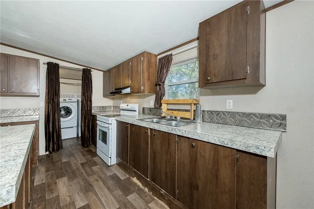 a kitchen with a sink a counter top space stainless steel appliances and cabinets