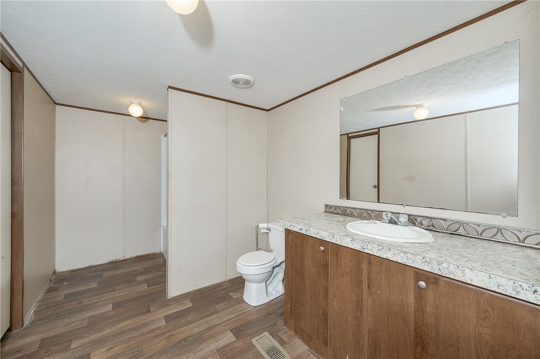 604 Sanders Rd. Lane Franklin, TX 77856 - Photo 24 of 42 a bathroom with a granite countertop sink a toilet and a mirror