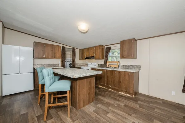 a kitchen with granite countertop a sink appliances a counter space and cabinets