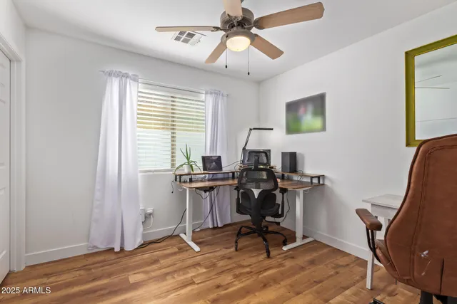 a view of a workspace with furniture and a window