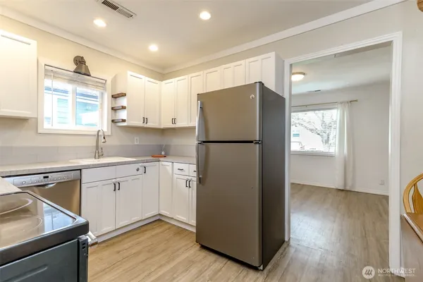 a kitchen with a refrigerator sink and cabinets