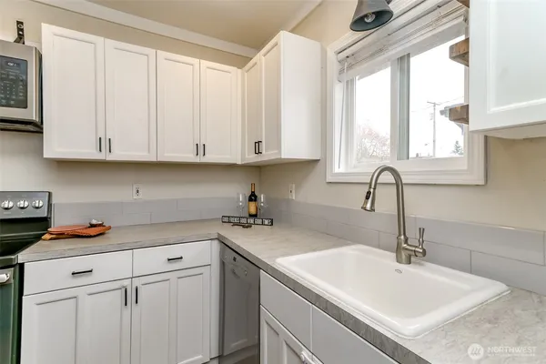 a kitchen with stainless steel appliances granite countertop a sink and a white cabinets