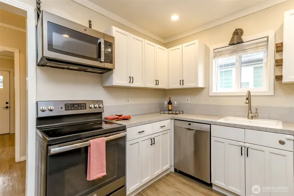 a kitchen with cabinets stainless steel appliances and a window