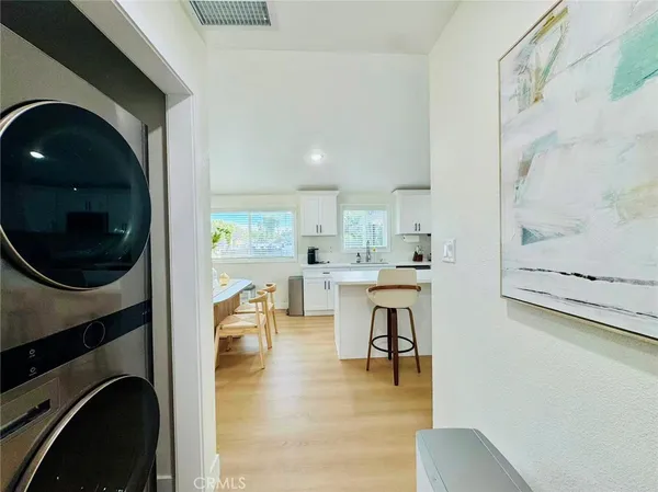 a living room with stainless steel appliances furniture a rug and a window