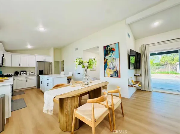 a living room with stainless steel appliances furniture and a kitchen view