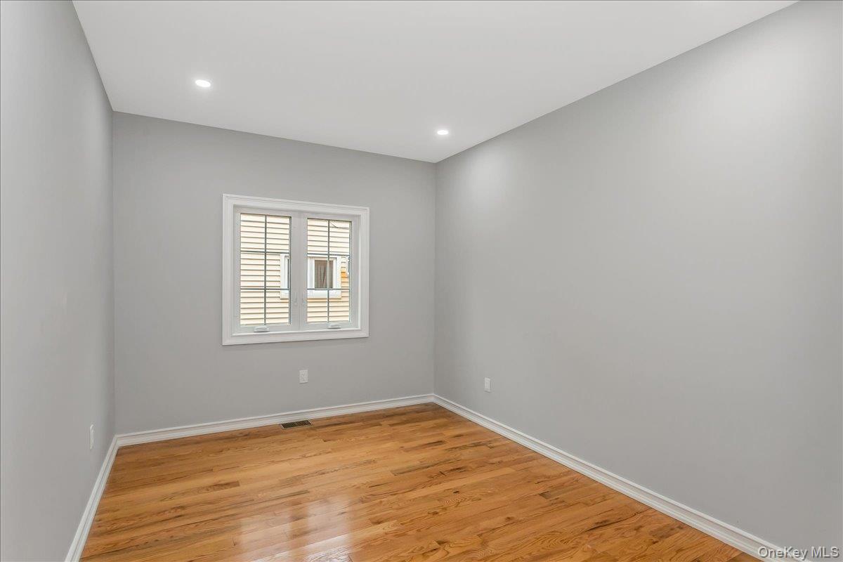 243-36 Caney Road Queens, NY 11422 - Photo 14 of 30 a view of empty room with wooden floor and fan