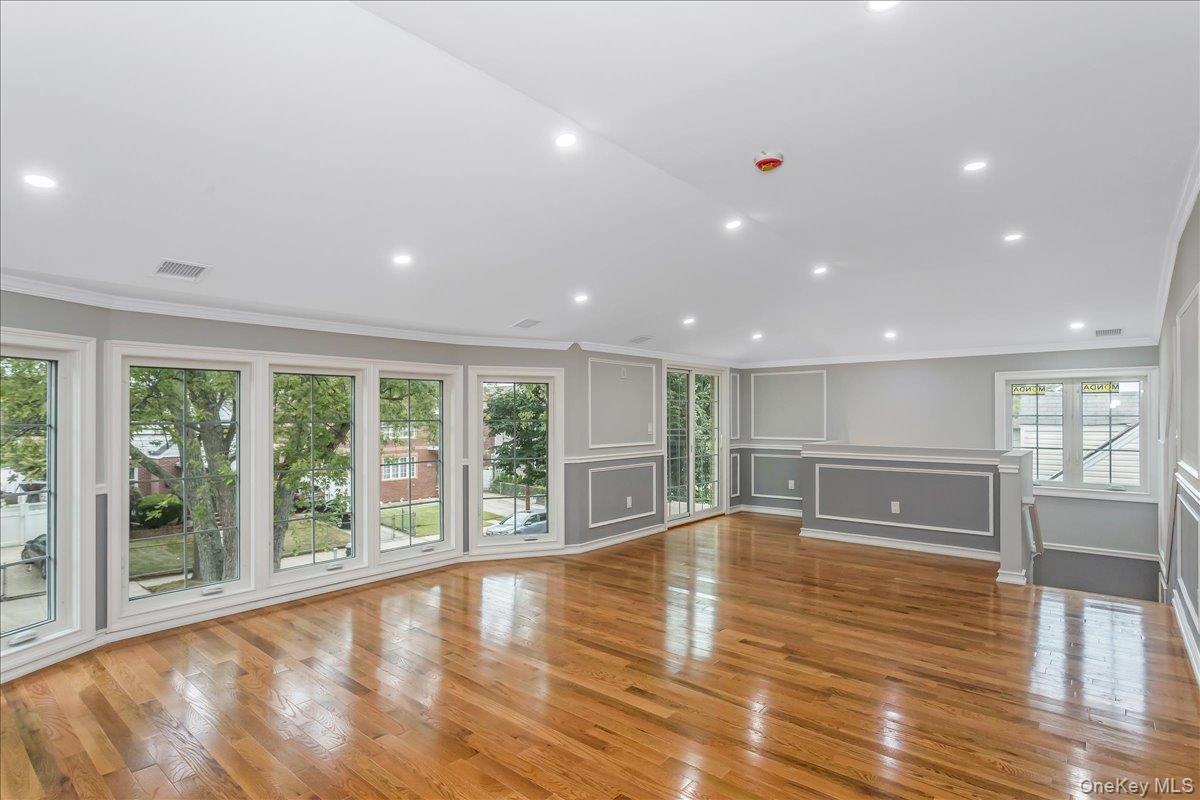 243-36 Caney Road Queens, NY 11422 - Photo 17 of 30 a view of empty room with wooden floor and balcony