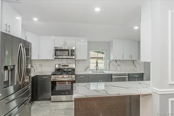 a kitchen with granite countertop a sink and a stove top oven