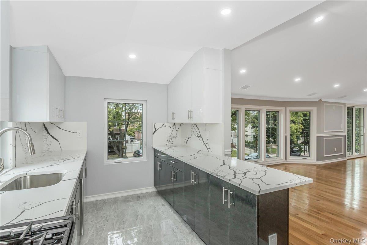 243-36 Caney Road Queens, NY 11422 - Photo 19 of 30 a kitchen with granite countertop a sink and a stove top oven