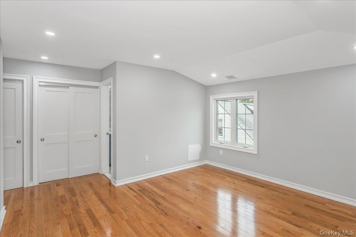 243-36 Caney Road Queens, NY 11422 - Photo 20 of 30 a view of empty room with wooden floor and fan