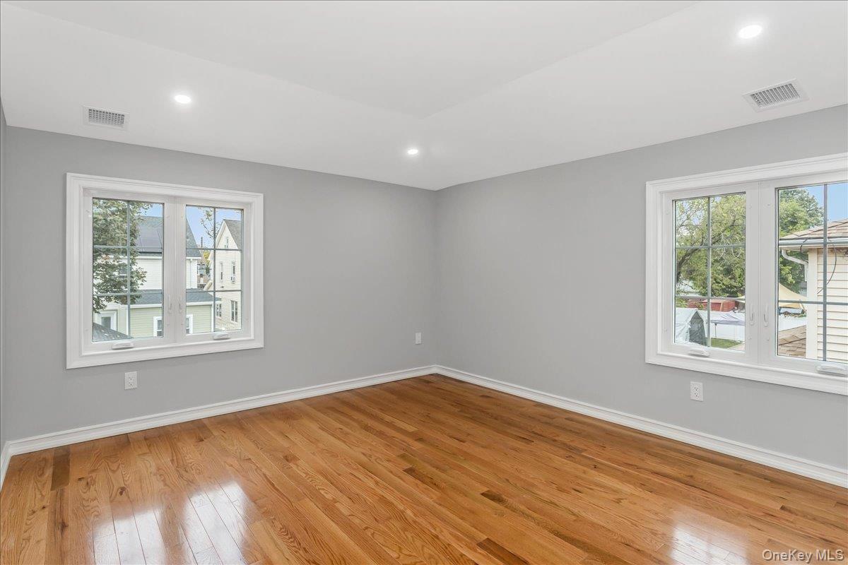 243-36 Caney Road Queens, NY 11422 - Photo 25 of 30 a view of empty room with wooden floor and fan
