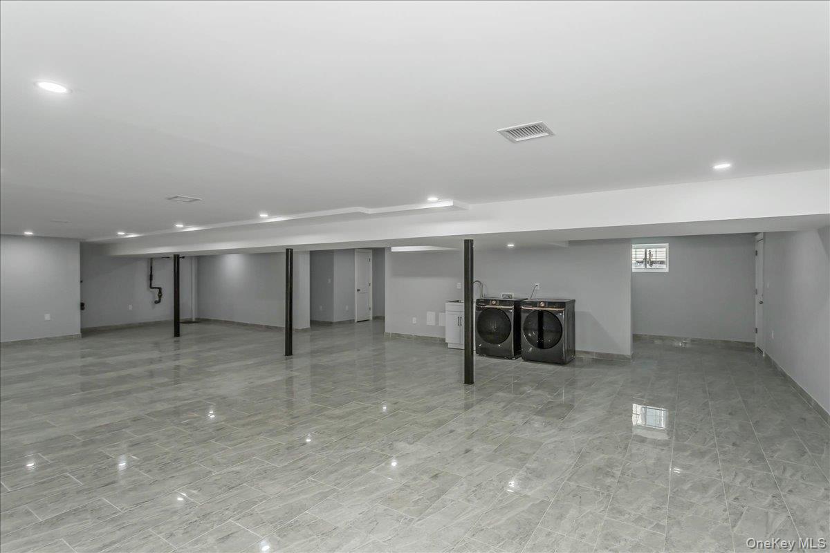 243-36 Caney Road Queens, NY 11422 - Photo 27 of 30 an empty room with a refrigerator and washer dryer