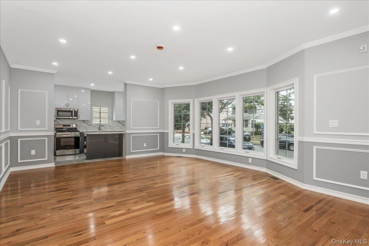 243-36 Caney Road Queens, NY 11422 - Photo 5 of 30 a large kitchen with stainless steel appliances granite countertop a large counter top and a wooden floors