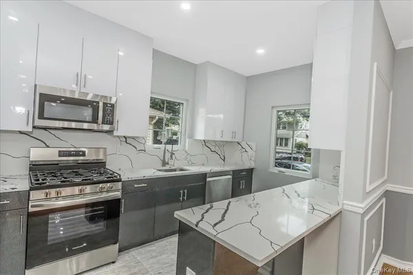 a kitchen that has a sink cabinets and stainless steel appliances