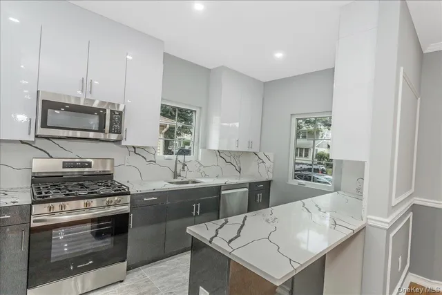 a kitchen that has a sink cabinets and stainless steel appliances