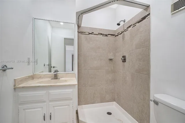 a bathroom with a shower sink vanity and mirror