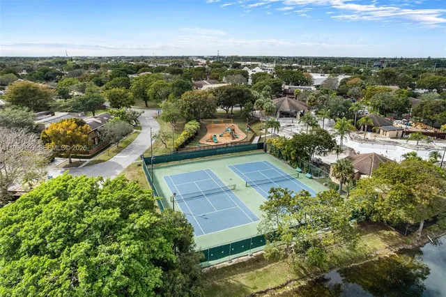 an aerial view of residential houses with outdoor space and trees